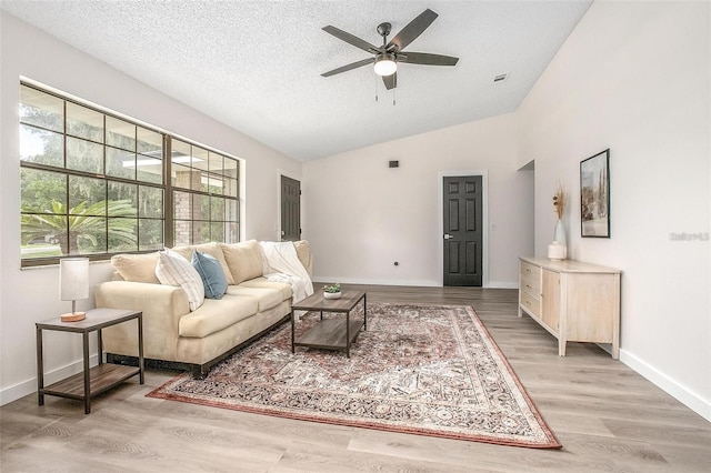 living room featuring hardwood / wood-style flooring, ceiling fan, a textured ceiling, and vaulted ceiling