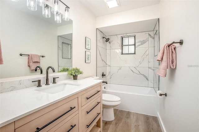 full bathroom featuring vanity, wood-type flooring, tiled shower / bath combo, and toilet