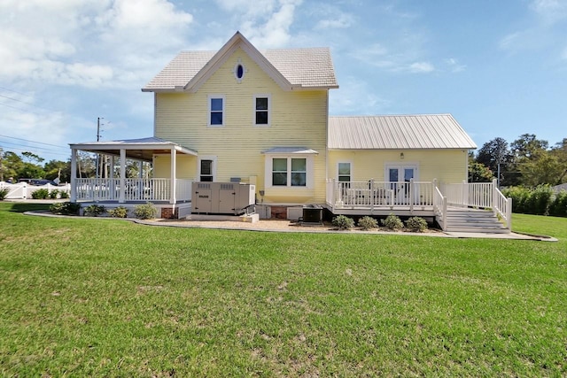 back of property featuring a deck, cooling unit, and a lawn