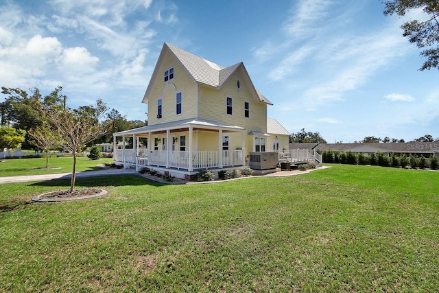 view of side of property featuring a porch, a yard, a hot tub, and cooling unit