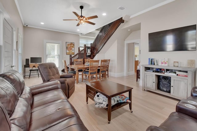 living room with light hardwood / wood-style flooring, ceiling fan, and crown molding