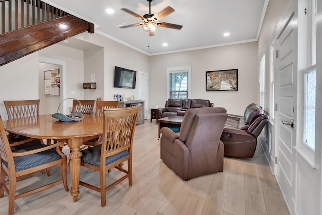 dining room featuring ceiling fan, light wood-type flooring, and crown molding