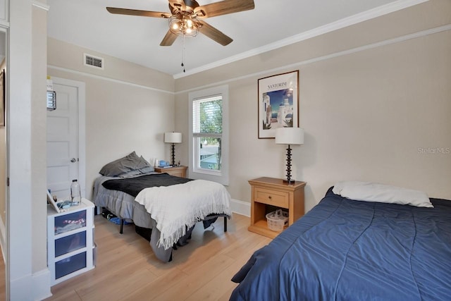 bedroom with ceiling fan, crown molding, and light wood-type flooring