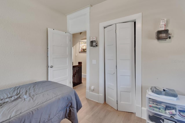 bedroom with light hardwood / wood-style flooring and a closet