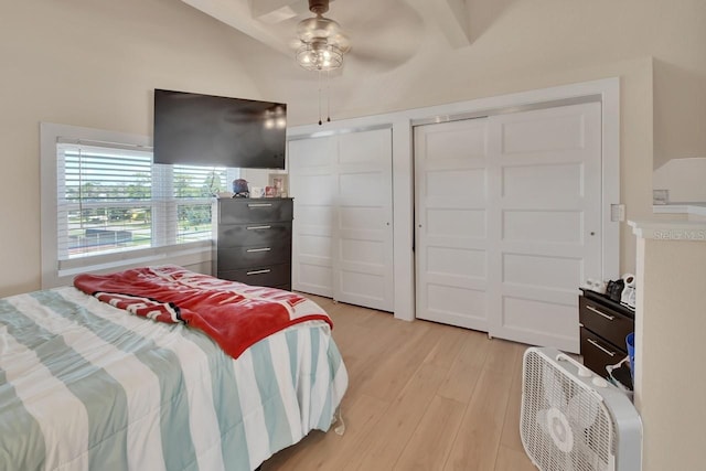 bedroom featuring ceiling fan, light hardwood / wood-style floors, and two closets