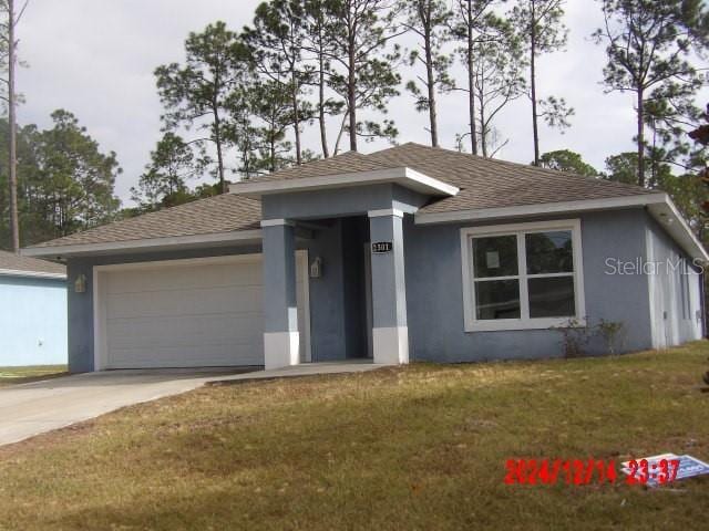 view of front of house featuring a garage and a front yard