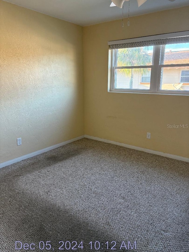 empty room featuring carpet floors and ceiling fan