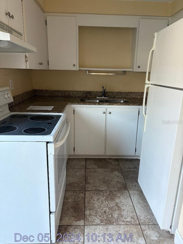 kitchen with white appliances, white cabinetry, and sink