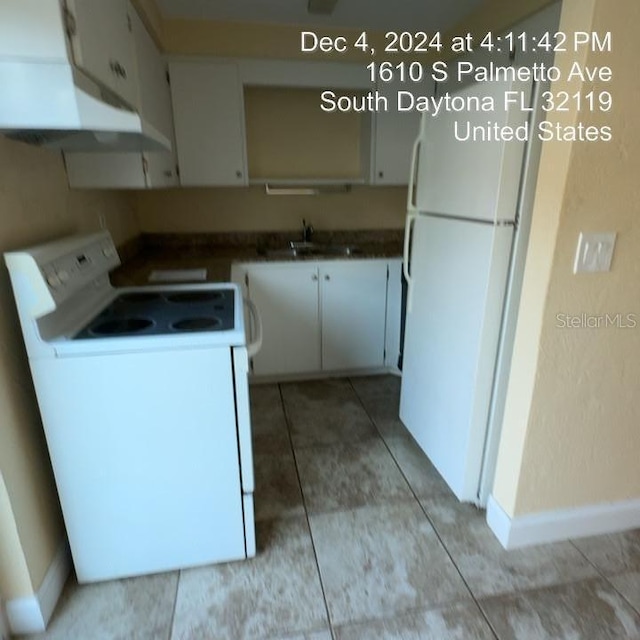 kitchen with white cabinets, white appliances, sink, and light tile patterned floors