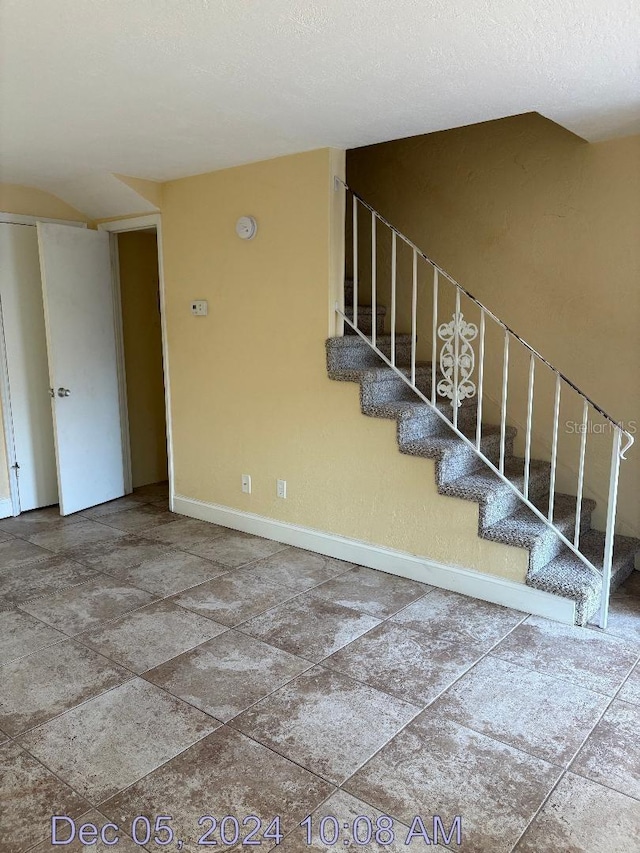 stairs featuring a textured ceiling