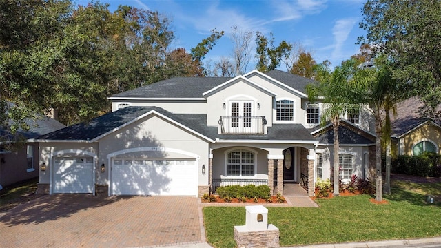 front facade featuring a porch, a front yard, and a garage