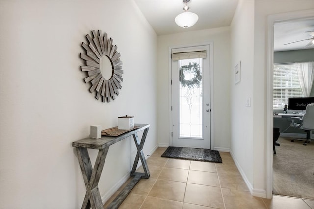 entrance foyer featuring a wealth of natural light, ceiling fan, and light colored carpet