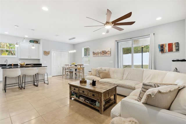 living room featuring ceiling fan, light tile patterned flooring, and sink