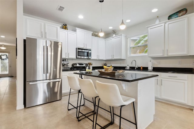 kitchen with pendant lighting, a center island, a healthy amount of sunlight, and appliances with stainless steel finishes