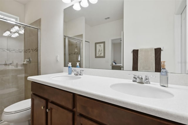 bathroom featuring vanity, a shower with shower door, and toilet