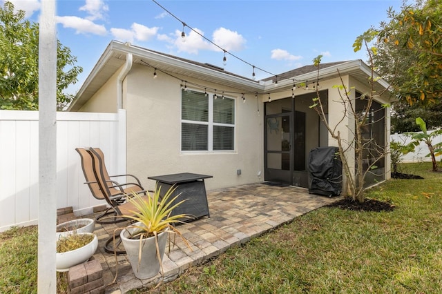 back of house featuring a sunroom, a patio area, and a yard