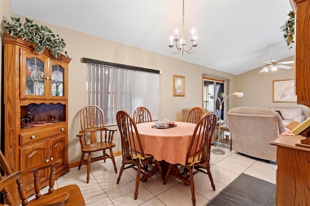 dining area featuring a textured ceiling, lofted ceiling, light tile patterned flooring, and ceiling fan with notable chandelier