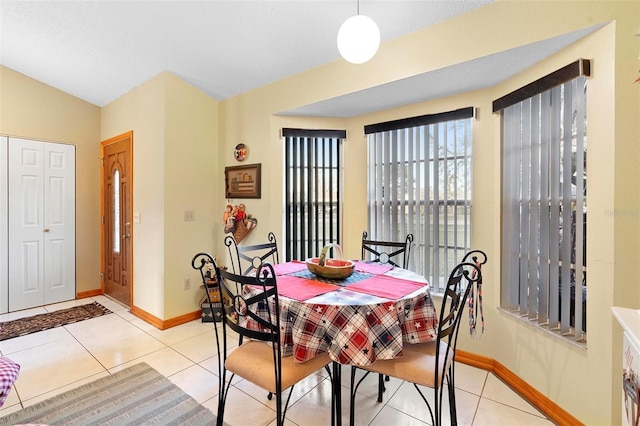 tiled dining room with lofted ceiling