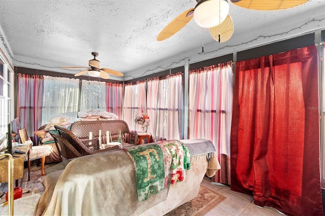 bedroom with ceiling fan, a textured ceiling, and light tile patterned floors