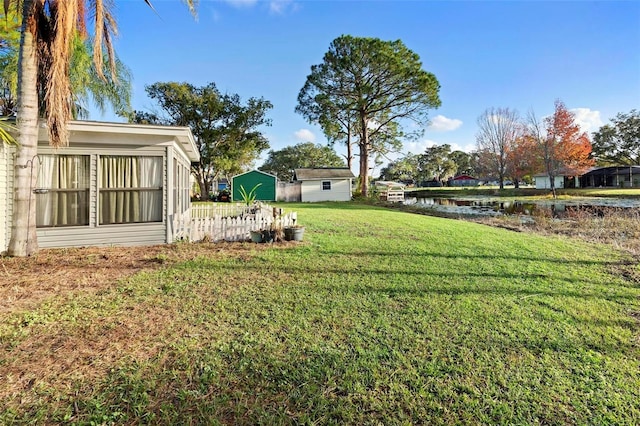 view of yard with a water view and a shed