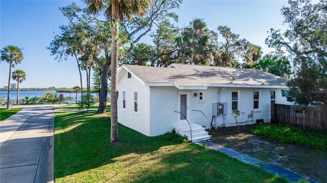 view of front of house with a water view and a front lawn