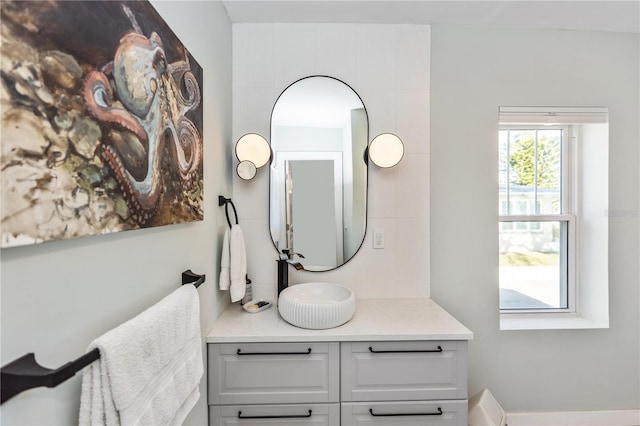 bathroom with vanity and tasteful backsplash