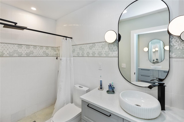 bathroom with vanity, toilet, tile walls, and curtained shower