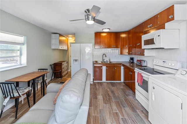 kitchen with sink, tasteful backsplash, dark hardwood / wood-style flooring, washer / clothes dryer, and white appliances