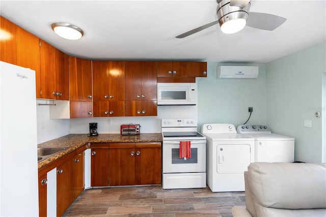 kitchen featuring white appliances, dark wood-type flooring, an AC wall unit, sink, and separate washer and dryer