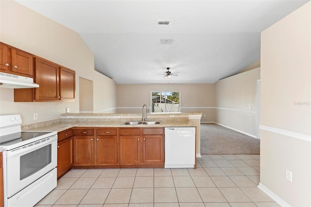 kitchen with white appliances, sink, vaulted ceiling, light tile patterned flooring, and kitchen peninsula