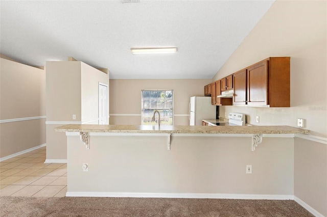 kitchen with a kitchen breakfast bar, kitchen peninsula, light colored carpet, and white appliances