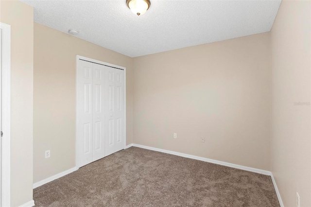 unfurnished bedroom featuring a closet, carpet, and a textured ceiling