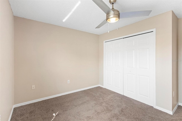 unfurnished bedroom featuring carpet flooring, ceiling fan, a closet, and a textured ceiling