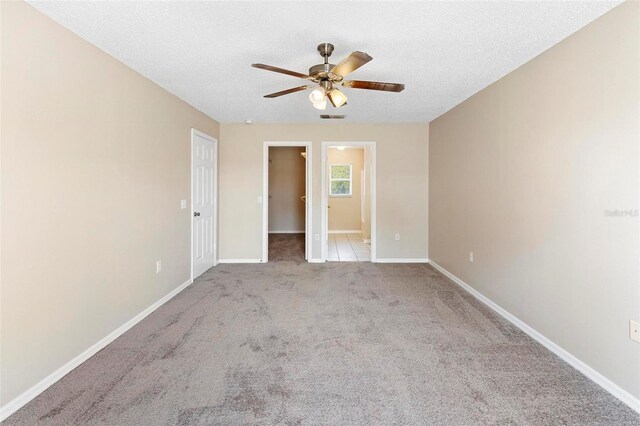 carpeted spare room with ceiling fan and a textured ceiling