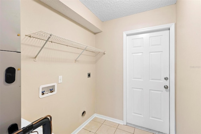 laundry area featuring electric dryer hookup, light tile patterned floors, washer hookup, and a textured ceiling