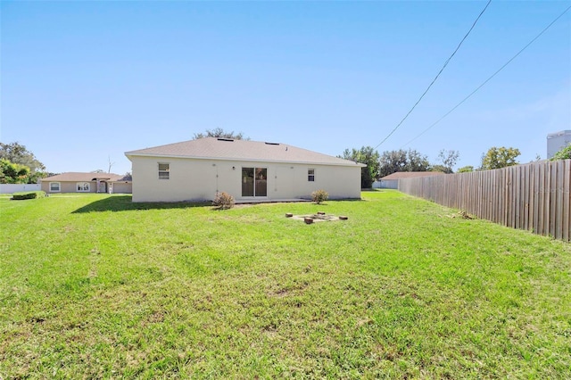 rear view of property featuring a lawn