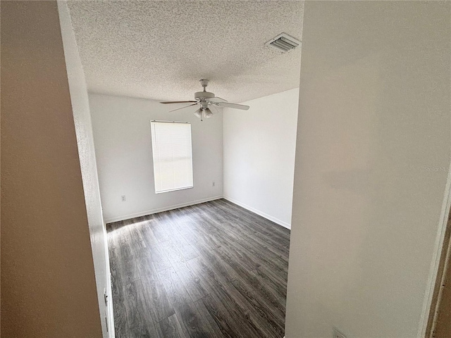 unfurnished room featuring ceiling fan, dark hardwood / wood-style flooring, and a textured ceiling