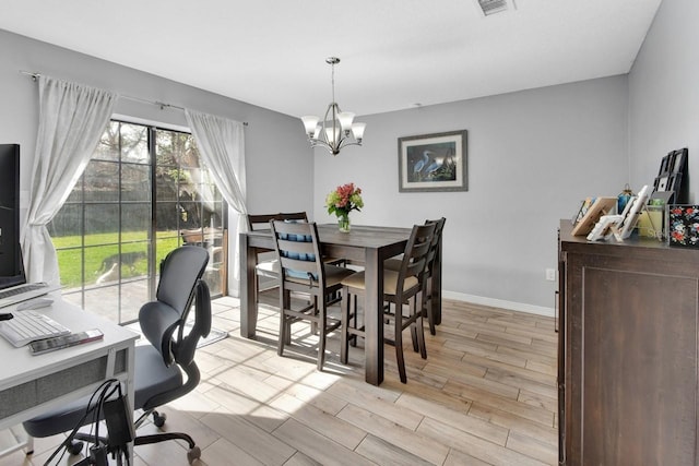 dining area with light hardwood / wood-style flooring and a chandelier