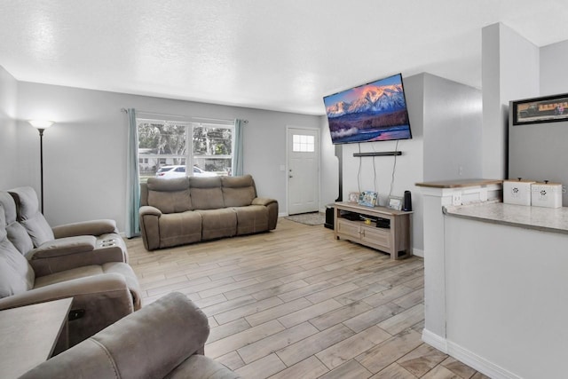 living room featuring light wood-type flooring and a textured ceiling