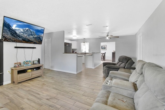 living room featuring light hardwood / wood-style floors and ceiling fan