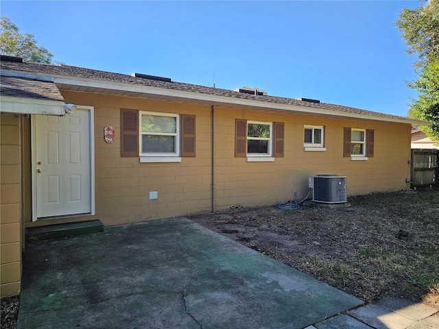 rear view of house with central AC and a patio area