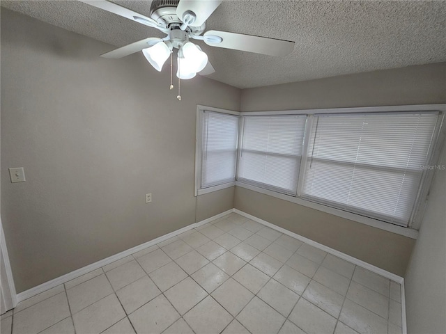 tiled empty room featuring a textured ceiling and ceiling fan