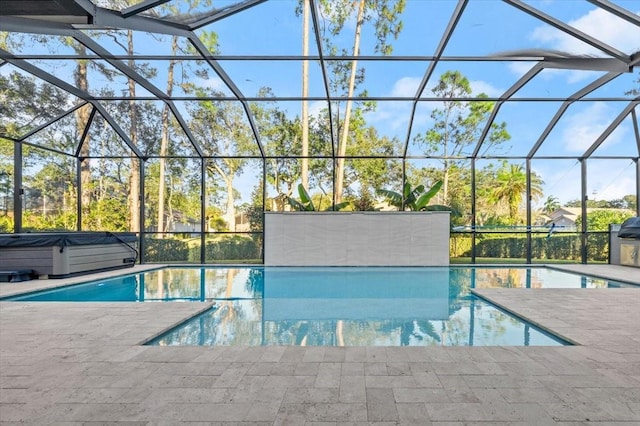 view of swimming pool with glass enclosure and a patio area