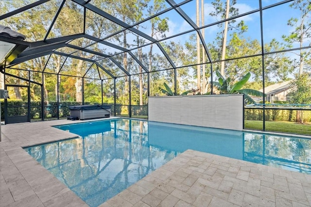 view of pool with glass enclosure, a patio, and a hot tub