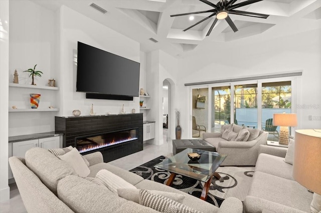 living room with a high ceiling, ceiling fan, coffered ceiling, and beam ceiling