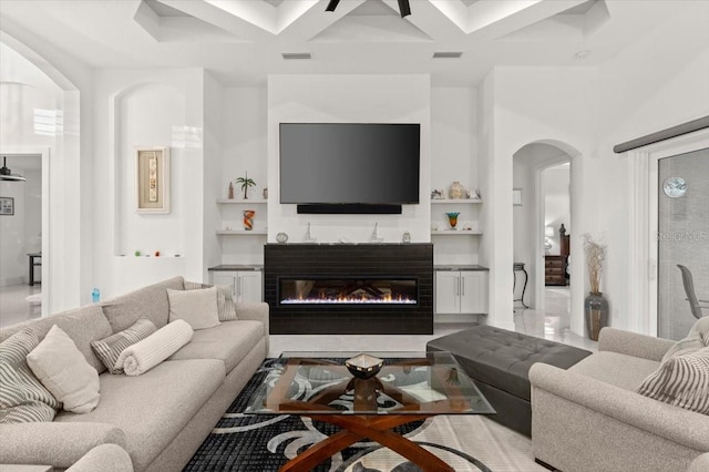 living room with beam ceiling, ceiling fan, and coffered ceiling