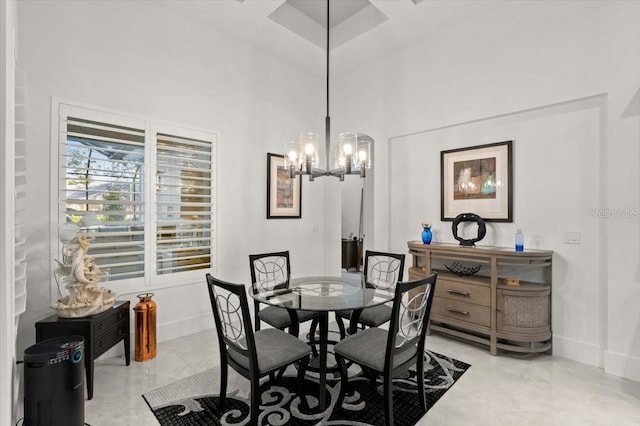 dining space with a chandelier and a high ceiling