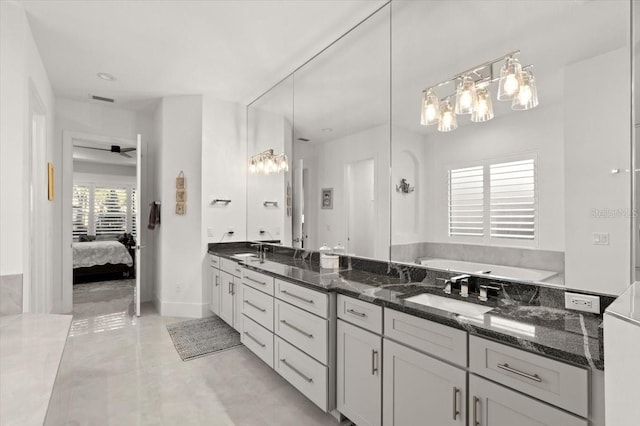 bathroom featuring tile patterned flooring, vanity, ceiling fan, and a tub