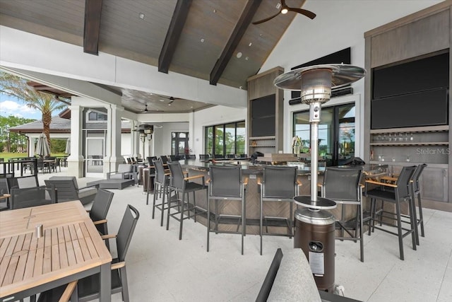 dining area featuring high vaulted ceiling, ceiling fan, beamed ceiling, wood ceiling, and decorative columns