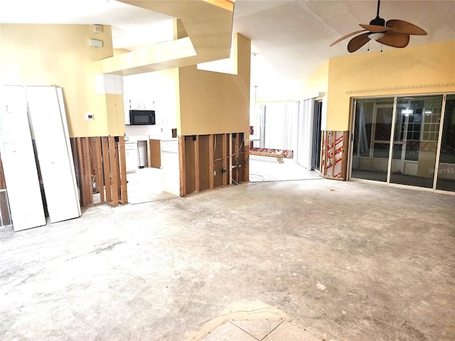 spare room featuring ceiling fan, concrete flooring, and a high ceiling